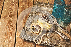 Vintage hand mirror and hairbrush on silver tray