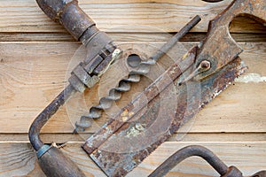 ,vintage  hand tools. on wooden table ,saw and hand drill  & bit labour day