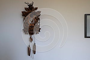 Vintage handmade wooden Cuckoo Clock on a white wall
