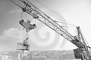 Vintage handyman having lunch on a crossbar hanging above the ci