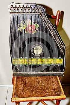 Vintage harp with a floral pattern on an antique chair