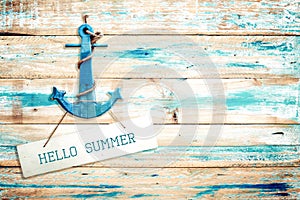 Vintage Hello summer sign hanging with anchor on old wooden blue paint background.