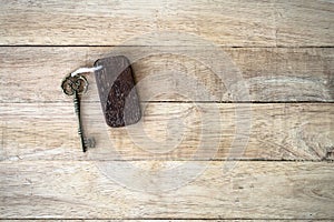 Vintage house key with wooden home keyring on old wood background