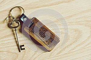 Vintage house keys and wood home keychain on wooden table background, key concept