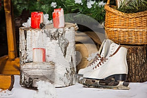 Vintage ice skates for figure skating with fir tree branch hanging on rustic background.
