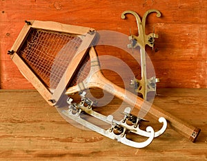 Vintage ice skates and tennis racket on wooden background. Retro ice skates and tennis raket.