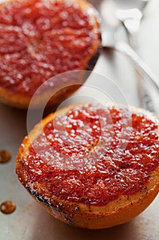 Vintage image of broiled grapefruit with brown sugar and cinnamon on metal surface, healthy dessert is good for breakfast