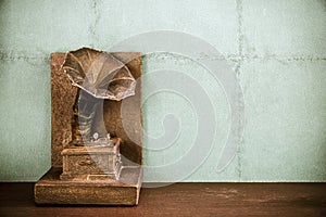 Vintage imitation turntable or gramophone on wall background.