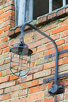 Vintage industrial broken lantern on a brick wall