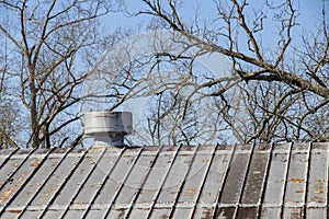 Vintage industrial look of a vented standing seam metal roof on a bright winter day.