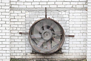 Vintage Industrial Ventilation Fan Against White Brick Wall