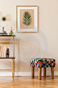 Vintage interior design of living room with design retro stool and shelf, book, accessories and gold mock up poster frame.