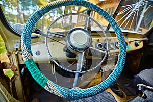 Vintage interior of an old car with a retro dashboard and steering wheel in a PVC cover