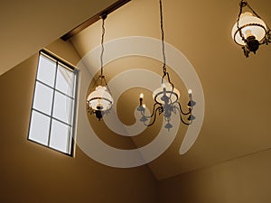 Vintage iron chandelier under the gable roof in the ancient house, Classic style vintage light lamp or candle bulbs hanging at