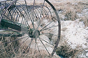 Vintage iron wheel in the field. An old chariot among the grass. Spokes in the wheels of the cart