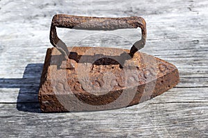 Vintage rusty iron on a wooden table. Retro style