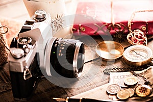 Vintage items, pen red book, coins money, compass and retro photo film camera on wood background