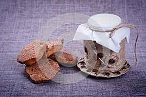 Vintage jar of white flour stands in the middle of a pile of grain o