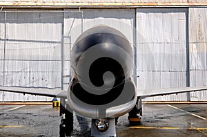 Vintage jet fighter aircraft in front of hangar