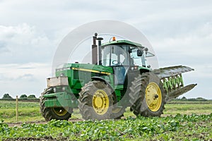 Vintage John Deere tractor pulling a plough