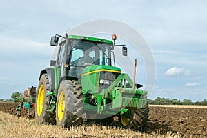 Vintage John Deere tractor pulling a plough