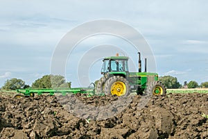 Vintage John Deere tractor pulling a plough