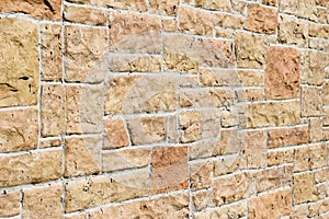 Vintage kasota limestone brick wall texture in colors of orange and pink beige