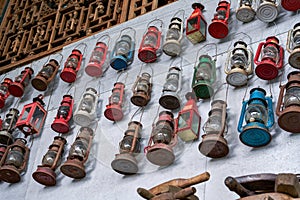 Vintage kerosene lamps hanging all over the wall for sale in a thrift store