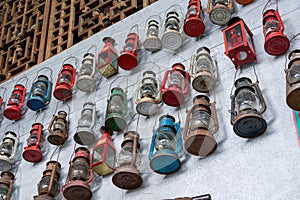 Vintage kerosene lamps hanging all over the wall for sale in a thrift store