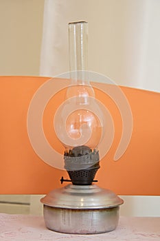 Vintage kerosene oil lantern lamp burning with a soft glow light in an antique rustic country barn with aged wood floor