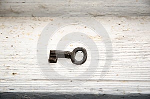 Vintage key at dirty white surface
