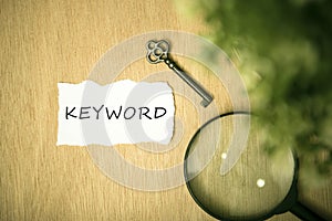 Vintage Key and torn paper with text keyword on wooden