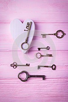Vintage keys collection and pink heart. Key Love and key Dream on the pink background. Top view, free space