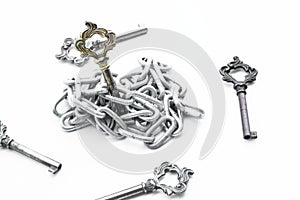 Vintage keys put in iron chain, surrounding with other keys on white background