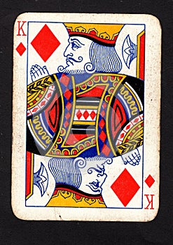 A vintage king of diamonds playing card on a black background.