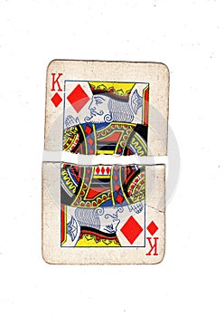 A vintage king of diamonds playing card torn in half.