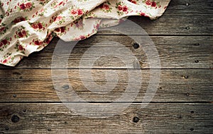 Vintage kitchen tablecloth on rustic wooden table made of rough old wood planks. Textured background with copy space