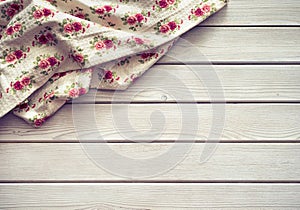 Vintage kitchen tablecloth on rustic wooden table made of white wood planks. Textured background with copy space