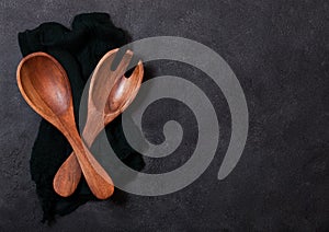 Vintage kitchen wooden utensils over black cloth on stone table background. Top view. Space for text