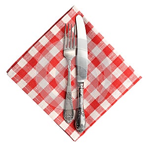 Vintage knife and fork on red plaid linen napkin isolated.