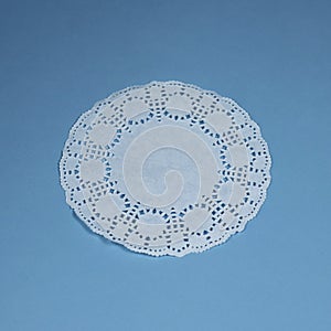 Vintage lace doily tablecloth knitted handmade grey blue colors on a white textured background