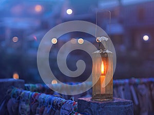 Vintage lamp with candle inside over blurry hostel background with pentagon bokeh