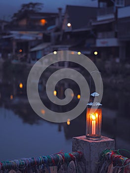 Vintage lamp with candle inside over blurry hostel background with pentagon bokeh