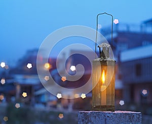 Vintage lamp with candle inside over blurry hostel background with pentagon bokeh