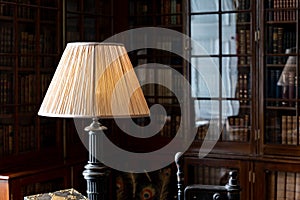 Starodávný lampa na psací stůl v historický knihovna skříň odraz v sklo 