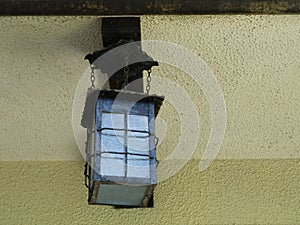 Vintage lamp like a lantern hanging on the wall of house
