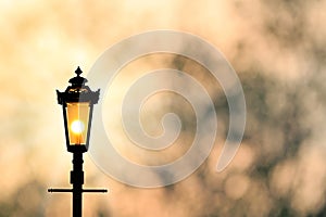 Vintage lamp post with sunset Background sillhouette