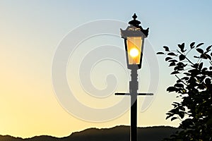 Vintage lamp post with sunset Background (sillhouette)