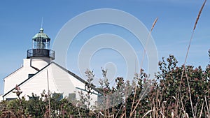 Vintage lighthouse tower, retro light house, old fashioned classic white beacon.