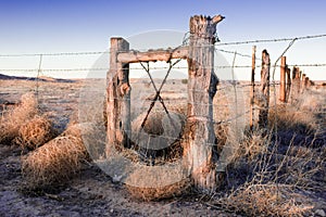 Vintage log fence on old Route 66 in New Mexico at sunset.